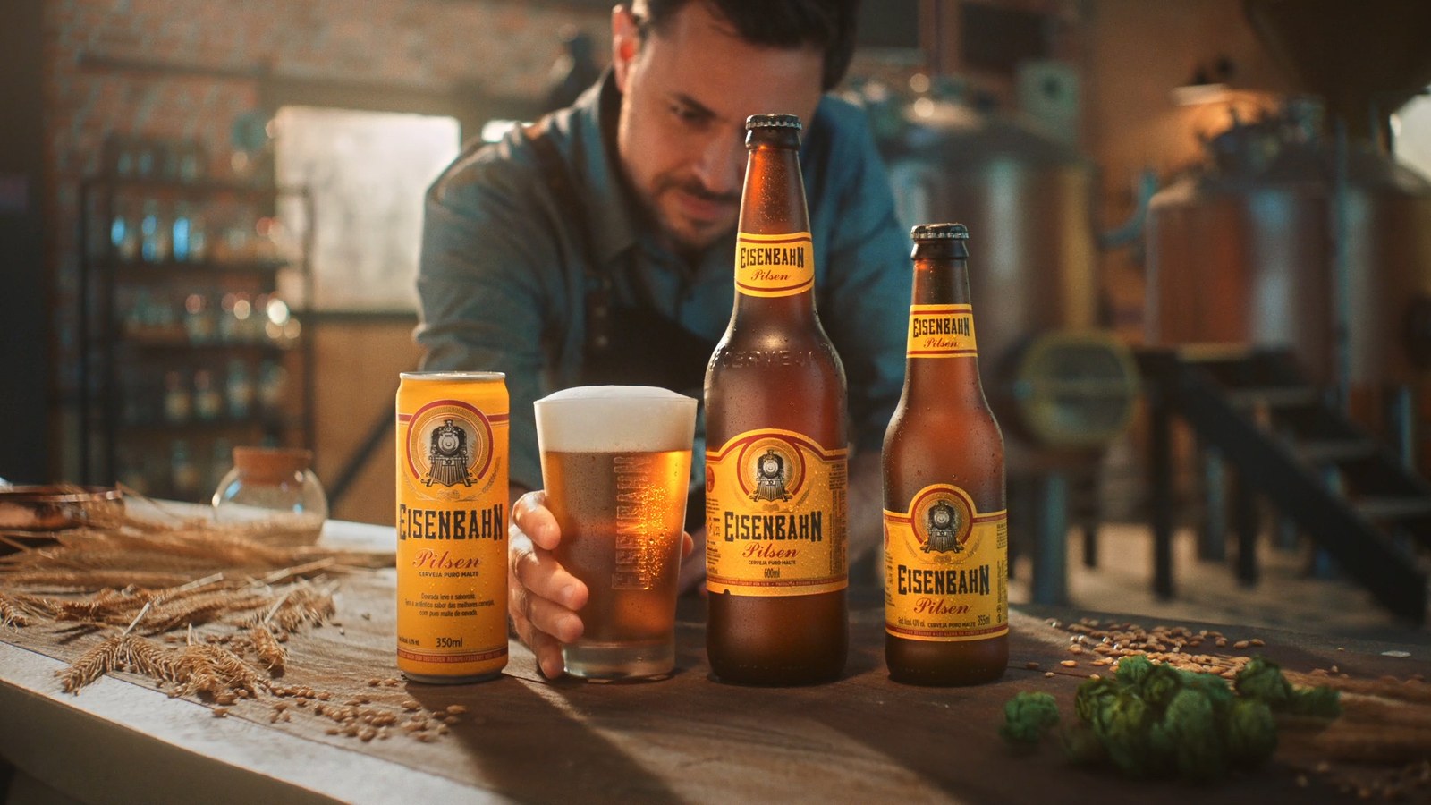 A brewer pouring a glass beside Eisenbahn bottles at the end of the film
