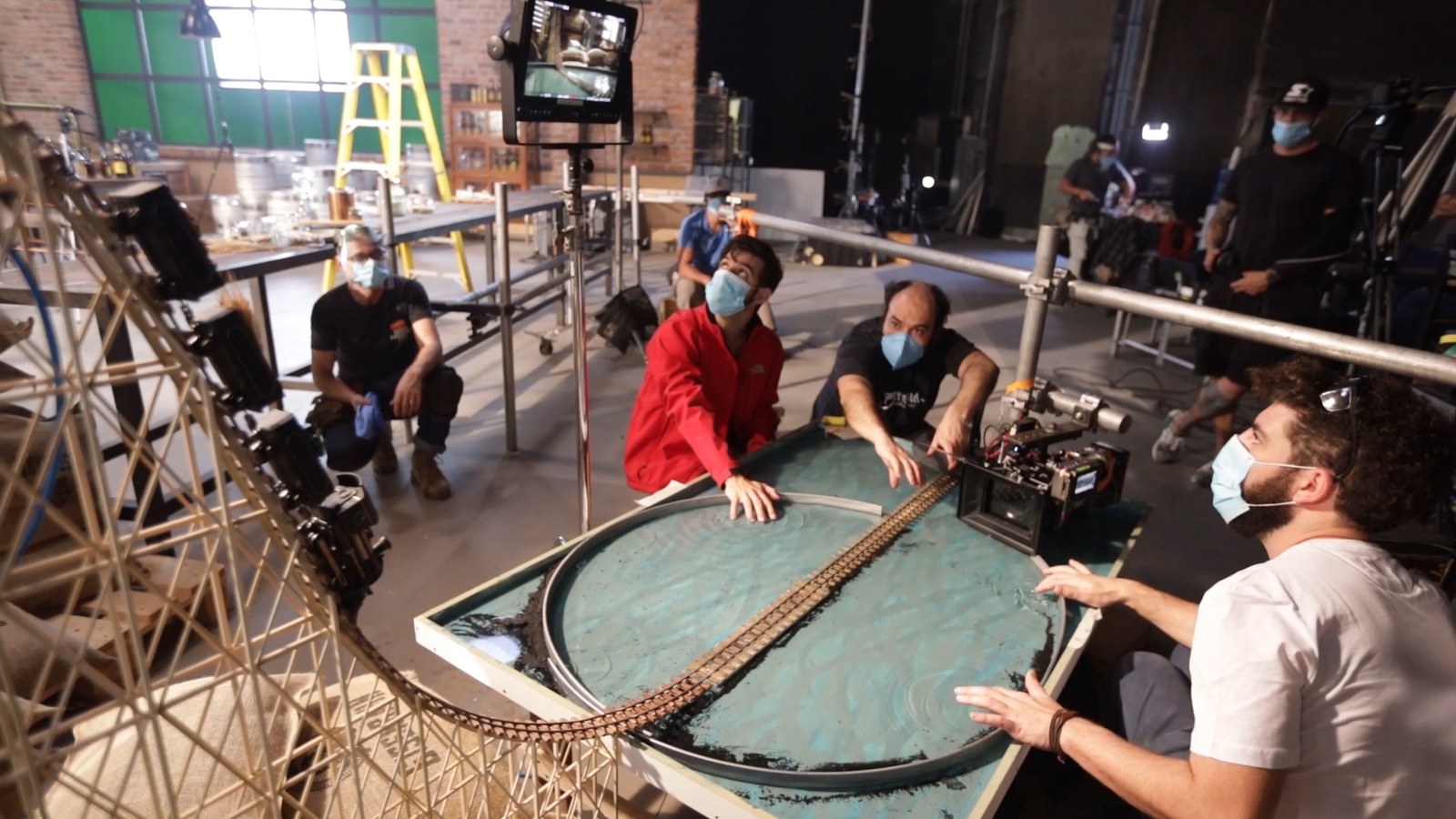 Crew gathered around a water tank set with the trestle track