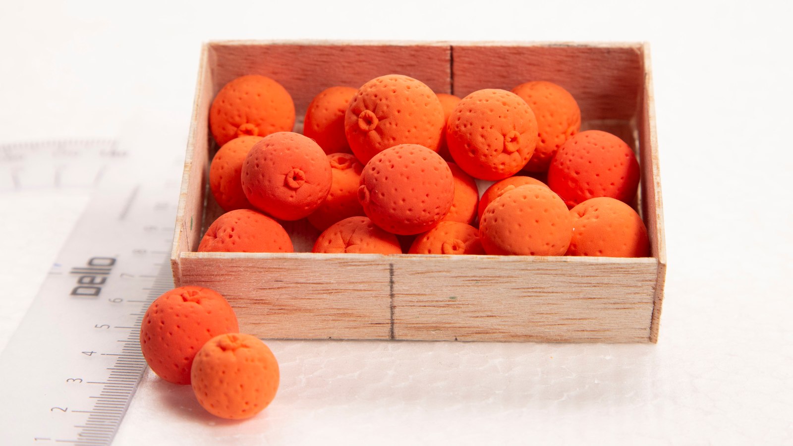Handmade miniature oranges in a wooden crate