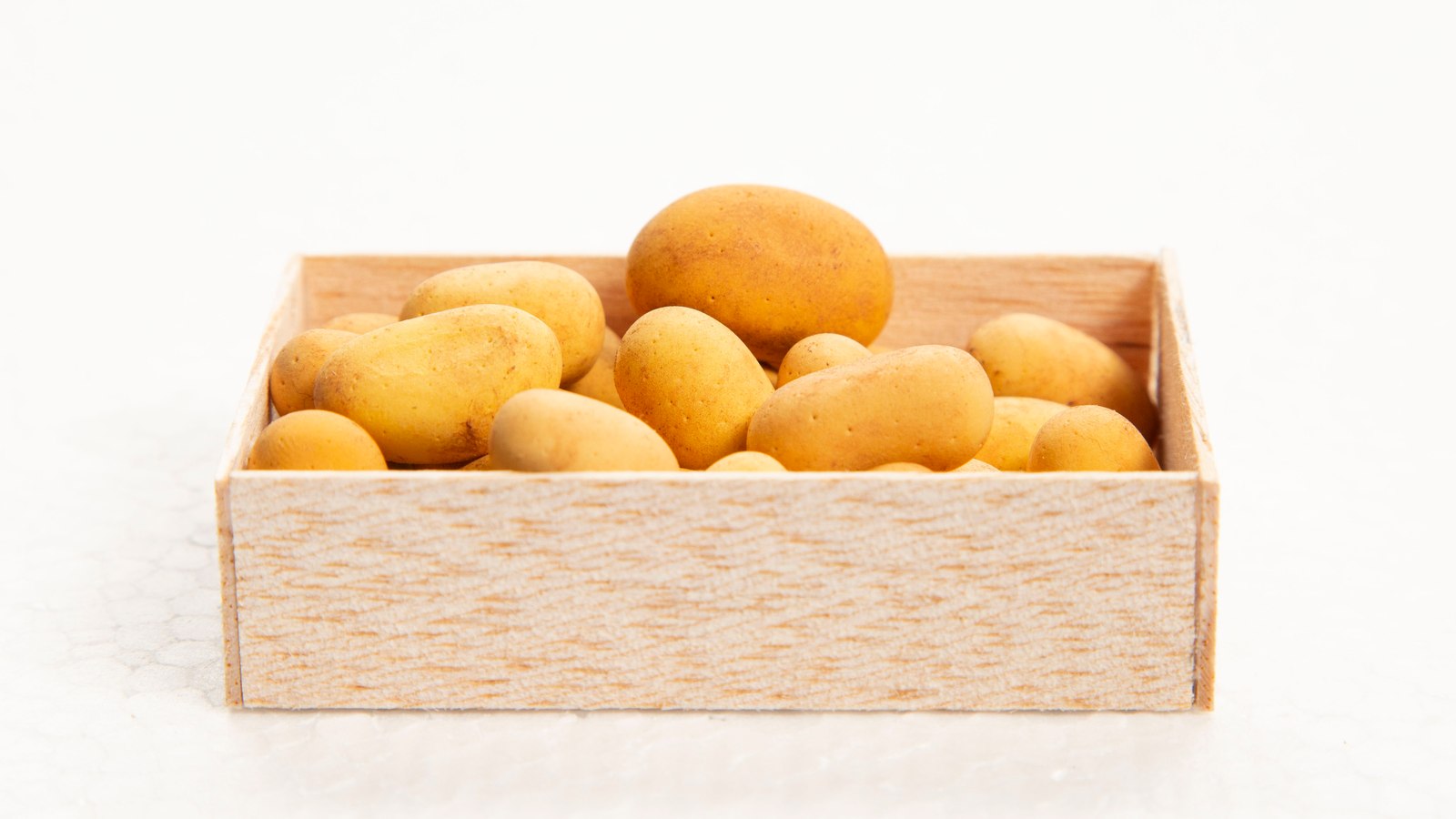 Handmade miniature potatoes in a wooden crate
