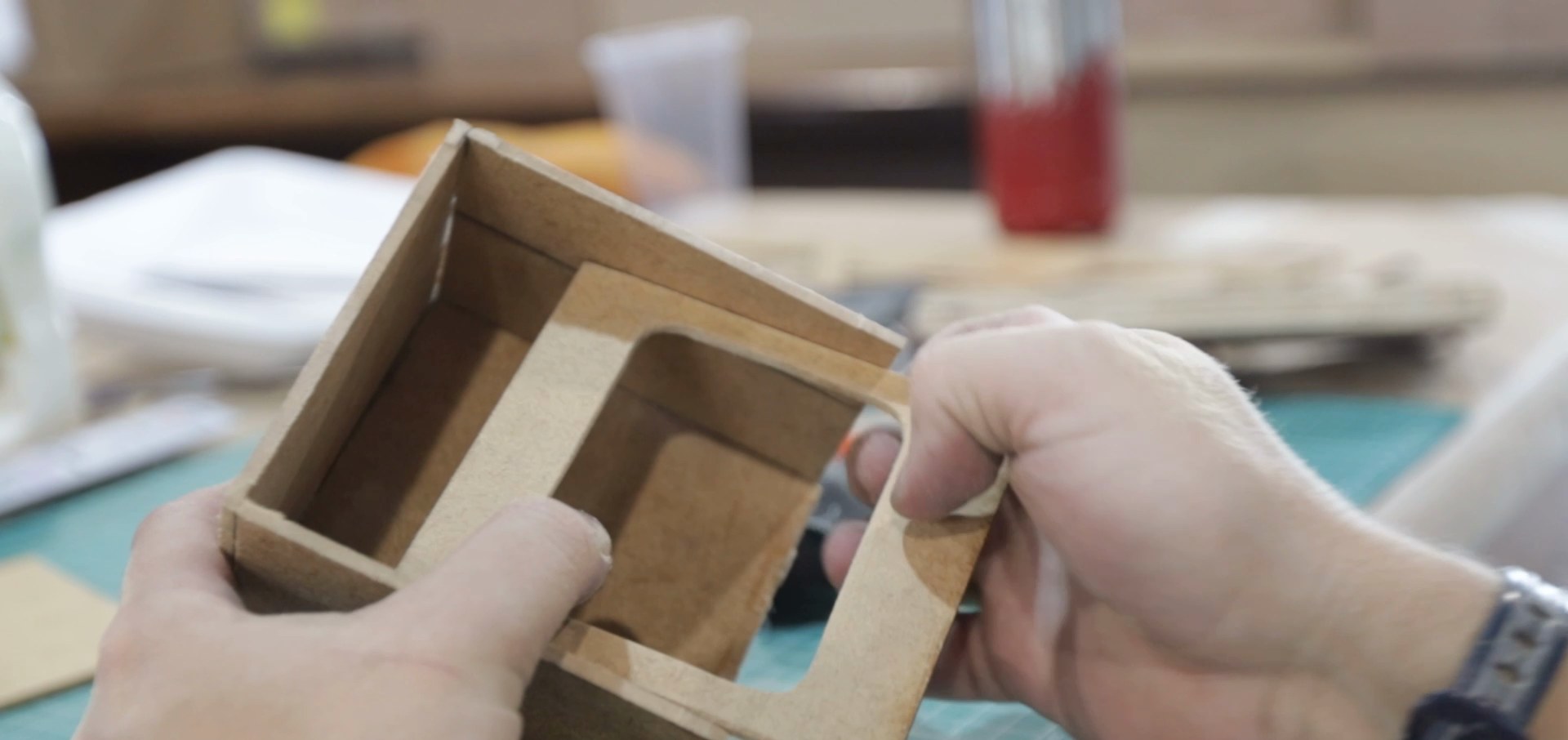 Hands holding a cardboard prototype of a set piece