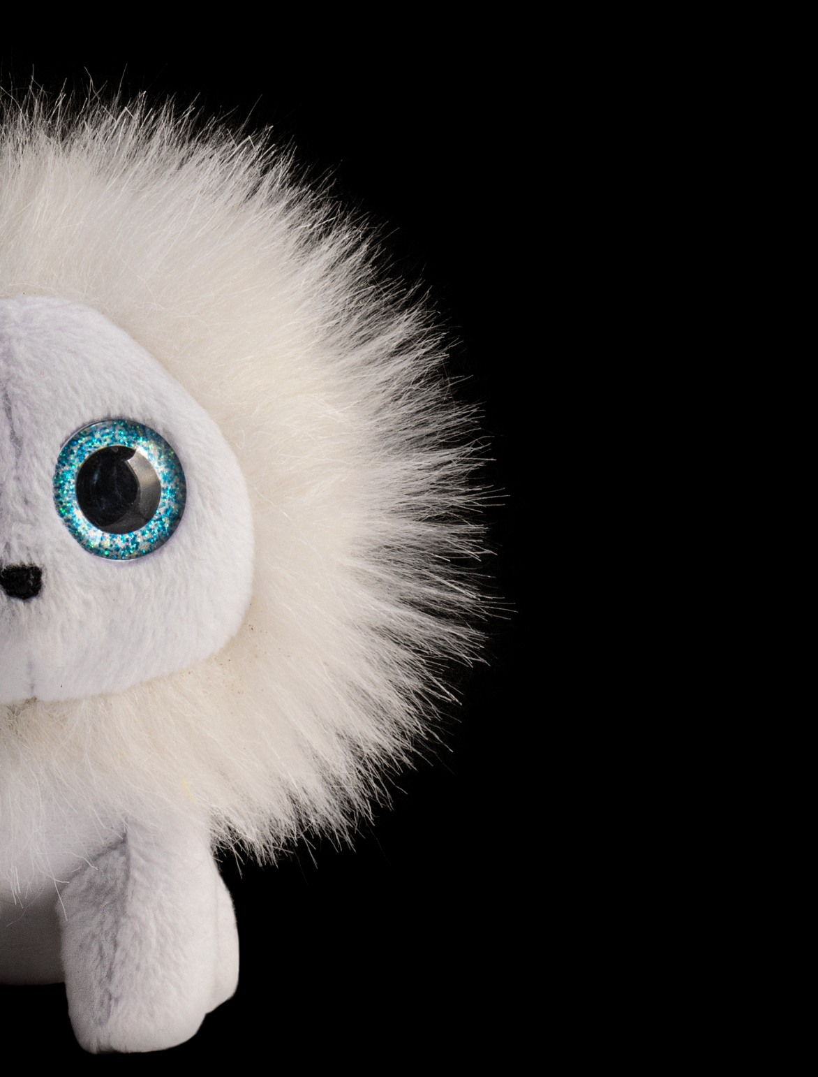 A white plush toy photographed against black, every fibre lit