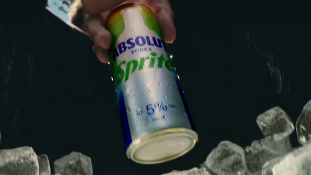 A hand pulls an Absolut Sprite can from a backpack packed with ice