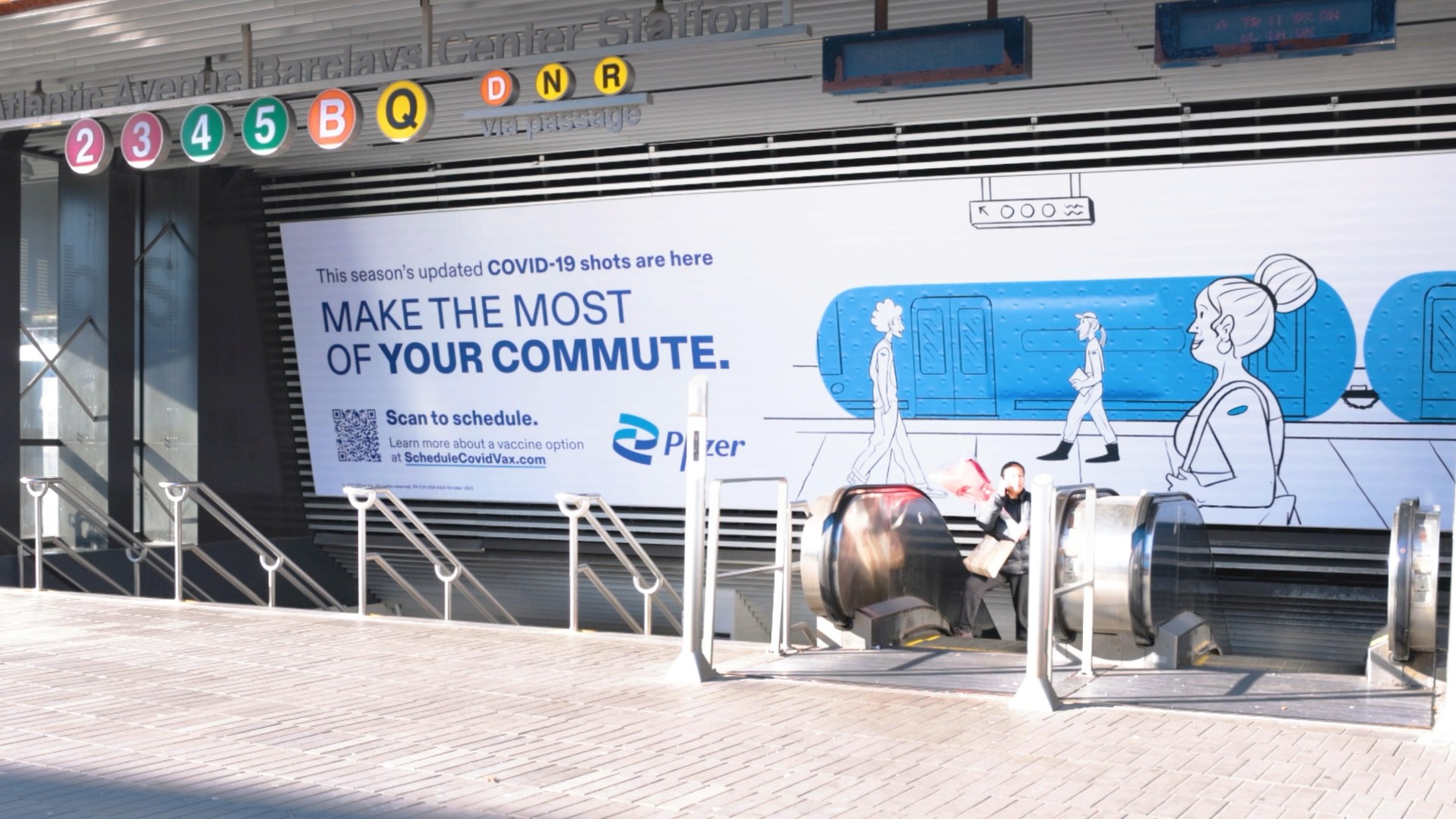 A subway entrance with Pfizer Doodles artwork reading Make the most of your commute