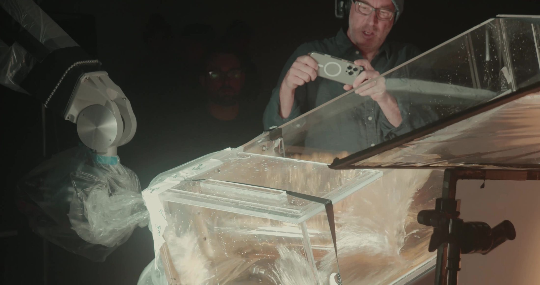 Crew operating a glass tank rig on the tabletop set to make a controlled wave