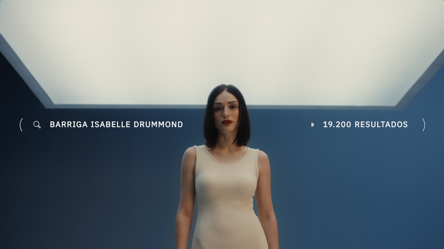 A woman under a light panel, the on screen search reading her name and belly