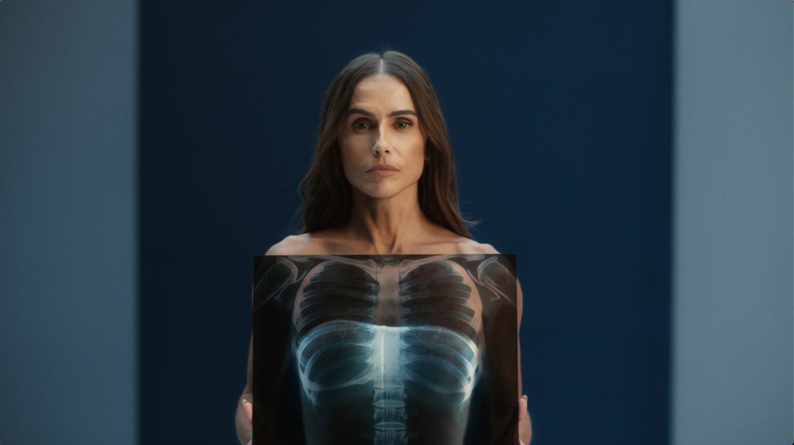 Research My Body, a woman standing with an X-ray of her ribcage across her chest